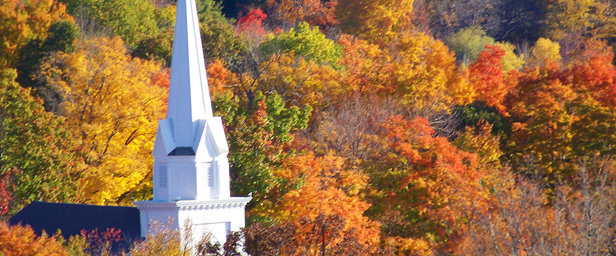 Fall foliage photo of the Ashburnham Community Church from a hilltop